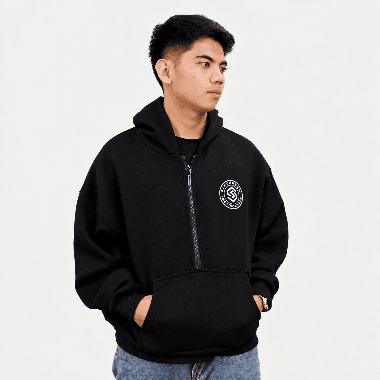 Rider in a black Sixthgear half-zip hoodie and jeans