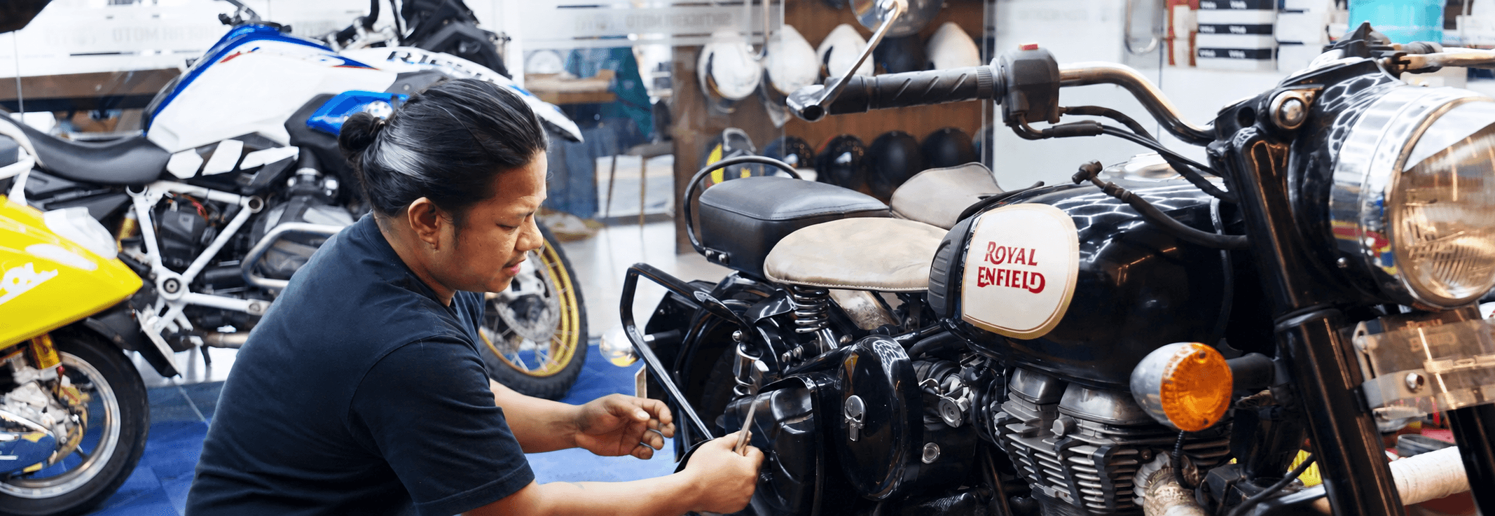 A SixthGear mechanic tightening a bolt on a Royal Enfield in the workshop